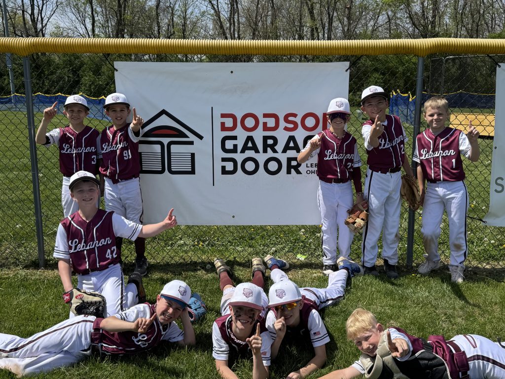 Kids celebrating by a sponsor banner